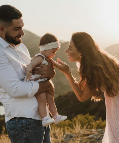 Father holding baby while mother looks lovingly at baby